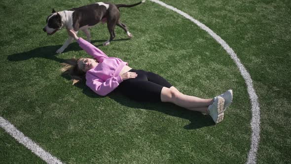 Top View Relaxed Happy Woman Lying on Green Grass with Purebred Dog Leaving in Slow Motion