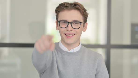 Portrait of Young Man Pointing at the Camera and Inviting