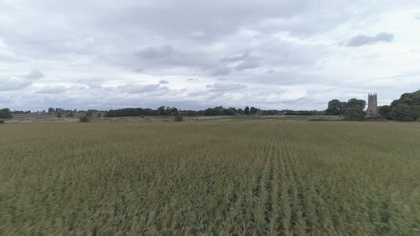 Low aerial pass over fields, flying close to the crop on an overcast day