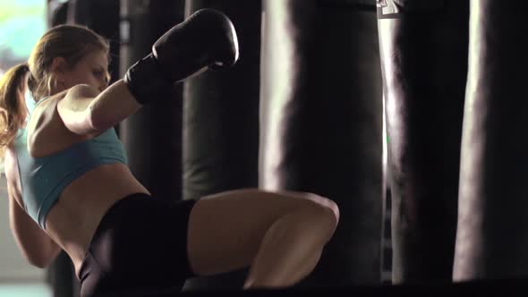 Woman does Muay Thai kickboxing training at the gym.