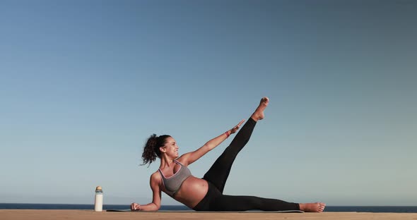 Young pregnant woman doing yoga outdoor - Sport exercises and maternity concept