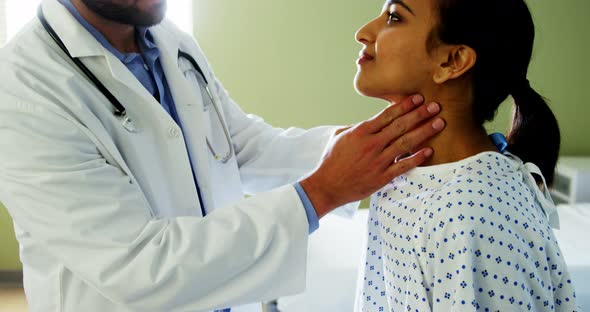 Doctor examining patients neck in the hospital