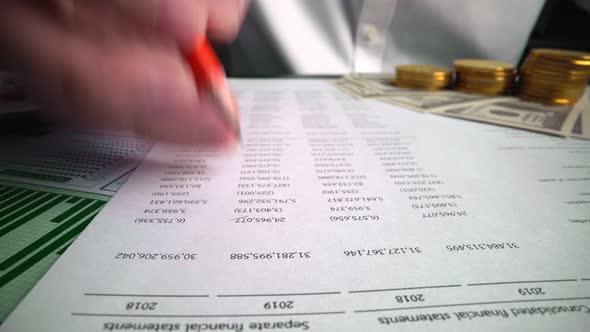 Accountant analyzing business marketing data on paper dashboard at office table.