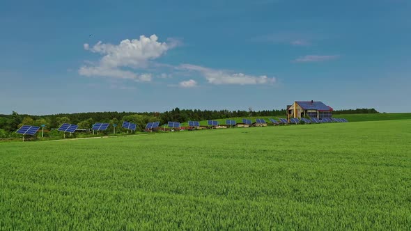 Green field in spring. Solar photovoltaic panels on the modern complex