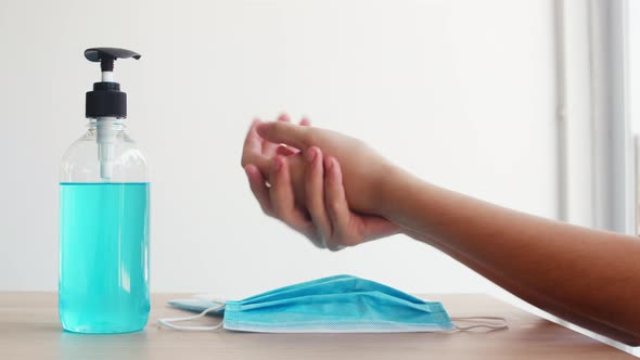 Asian woman using alcohol gel hand sanitizer wash hand before wear mask for protect coronavirus.