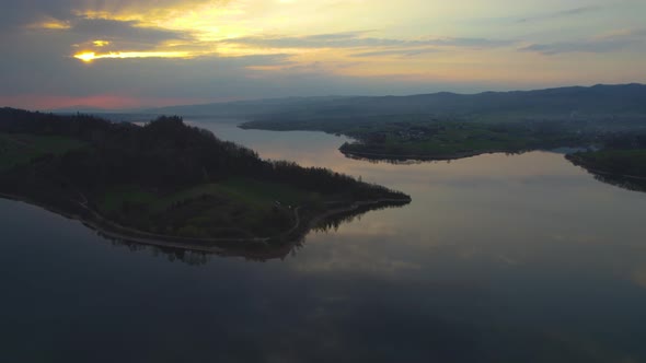 Sunset Reflection in Lake Czorsztyn in Poland, Ascending Drone View