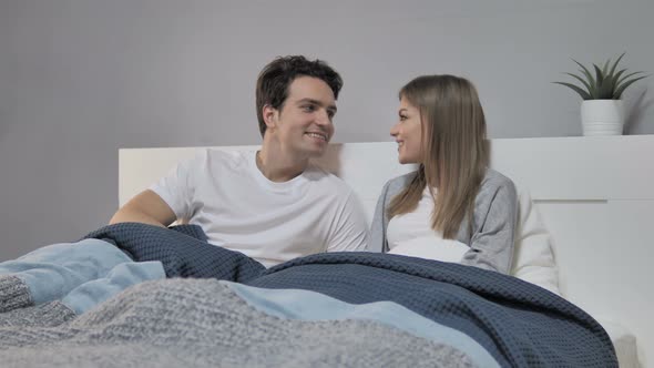 Talking Happy Couple Relaxing in Bed and Discussing Future