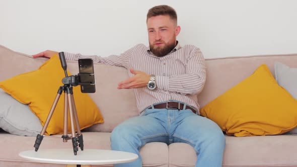 Caucasian Unshaven Blogger in Shirt and Jeans Tells News About New High Tech