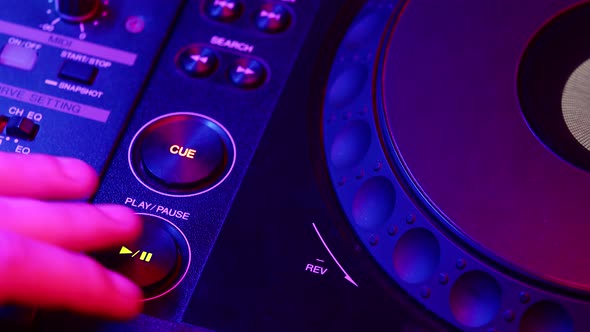 Male DJ's Hand Presses Play Button and Rotates Round Platform on Digital Mixing Console Closeup Side