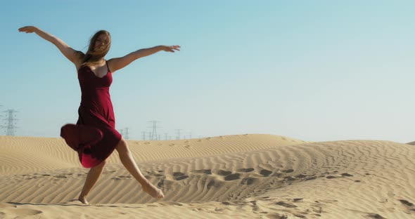 Windy Day in Great Sandy Desert of Dubai Woman in Red Dress is Dancing