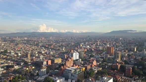Aerial - Flying over Bogota, views of tops of buildings and mountains in distance, Colombia