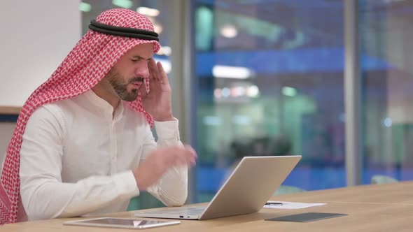 Stressed Arab Businessman with Laptop Having Headache