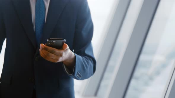 Video of businessman in suit holding smartphone