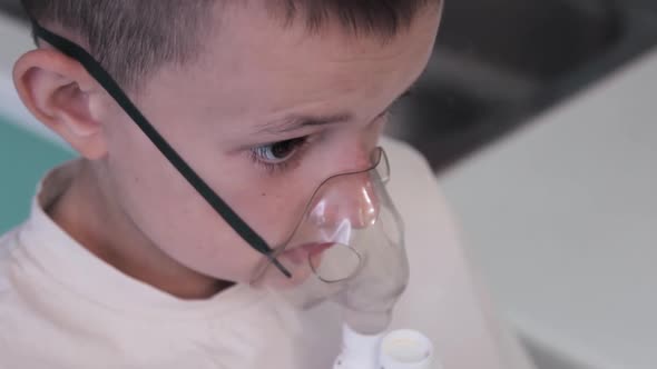 Child breathes an inhaler, being treated for colds and viruses