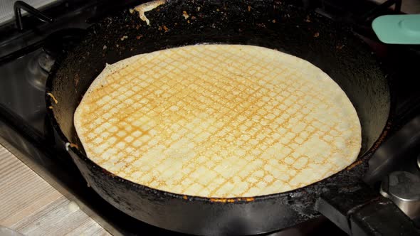 Delicious Yellow Pancake Lies on Hot Frying Pan on Stove