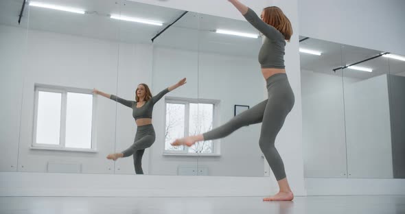 Dancer Woman Jumps in Slow Motion Infront of Mirror Wall Gymnastics in the White Dance Hall