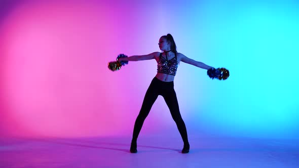 Energetic Cheering Dance Performed By Cute Cheerleader with Pompoms in Hands Against Blue Pink