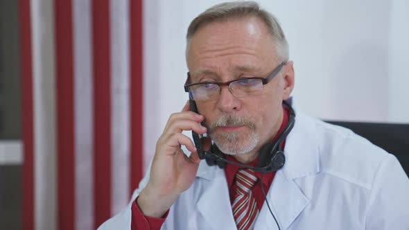 Serious doctor giving audio consultation call. 