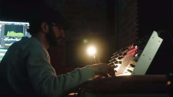 Close Up of Music Producer Working on Synthesizer