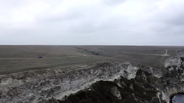 Shooting From Drone Offroad Suv Car Riding on Road Top of High Cliff Near Natural Sea Mountain