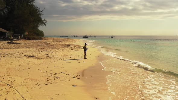 Angler good looking boy on vacation enjoying activities at beach on paradise white sand and blue bac