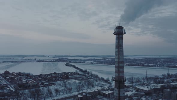 Aerial View of Smoke From the Boiler Pipe of an Industrial Facility in a Snowy Winter