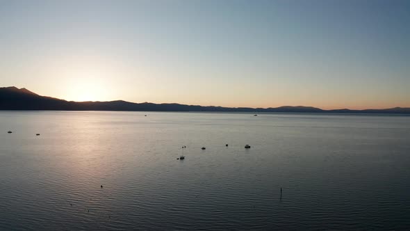 Rising aerial shot of boats on Lake Tahoe at sunset. 4K