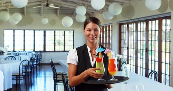 Smiling waitress offering a cocktail drink