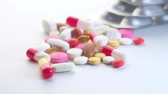 Close Up of Colorful Pills Spilling on White Background 