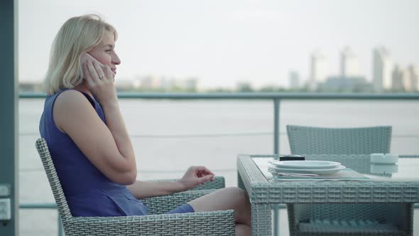 Attractive Blond Adult Woman Hanging Up Phone and Smiling,Side View Portrait of Charming Caucasian