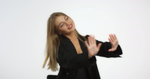 Beautiful Woman in a Black Shirt with Long Blond Hair Looks at Her Manicure