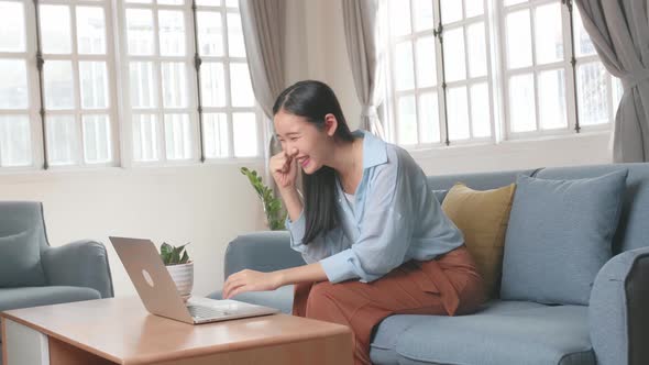 Female Use Laptop Computer And Celebrating In Living Room