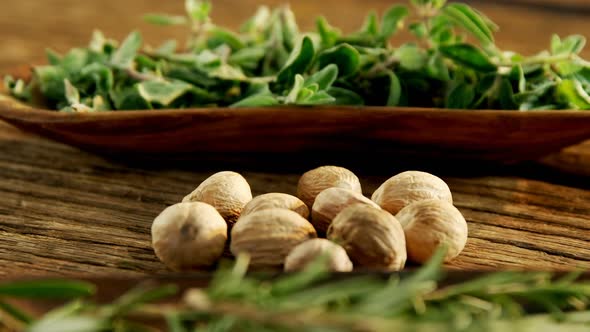 Nutmeg and herbs on a wooden table