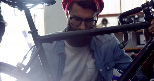 Mechanic repairing bicycle in workshop