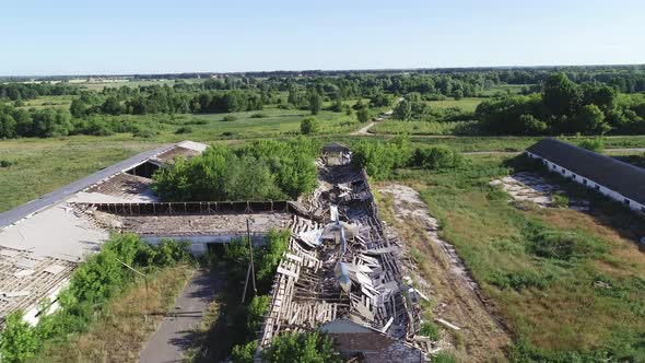 Flying Over an Abandoned and Destroyed Farm. Ruined Cowsheds and Farmyard.