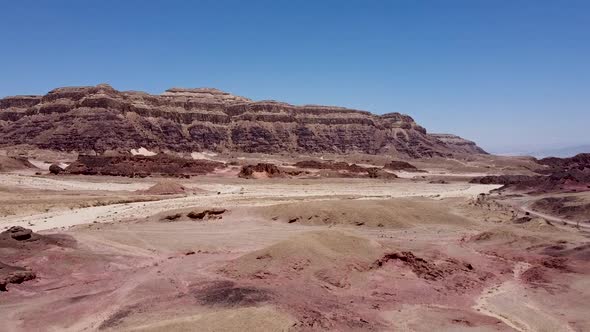 Aerial slow and calming rising wide drone shot of a multiple ground layered ridge in the middle of a