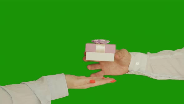 Man gives a woman a gift in a small box with a bow, chromakey