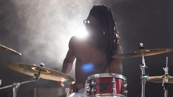 Vigorous African Man Wearing Eyeglasses Emotionally Playing Drums