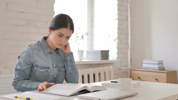 Young Girl Reading Book in Office