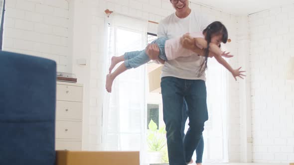 Mom, Dad, and child happy hold cardboard boxes for move object and having fun.