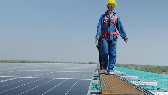 Female workers and engineers are exploring the installation of solar panels on the roof