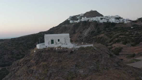 Flight Over Small Town Church on Greek Island Milos at Dusk