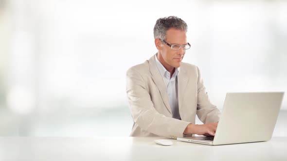 Elegant Businessman is Working on Desk with His Laptop