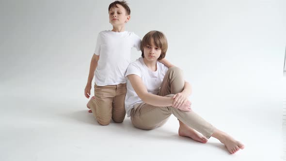 Two Boys in White Tshirts Pose for a Photographer in a Photo Studio