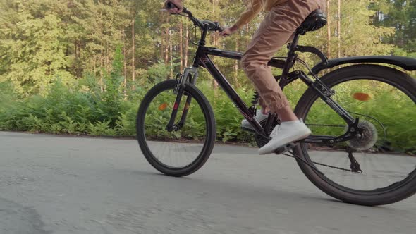 Unrecognizable Male Riding Bike In Park