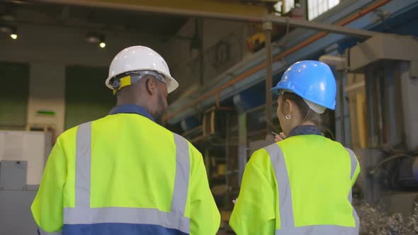 Manager and Supervisor Inspecting Modern Factory Plant alt