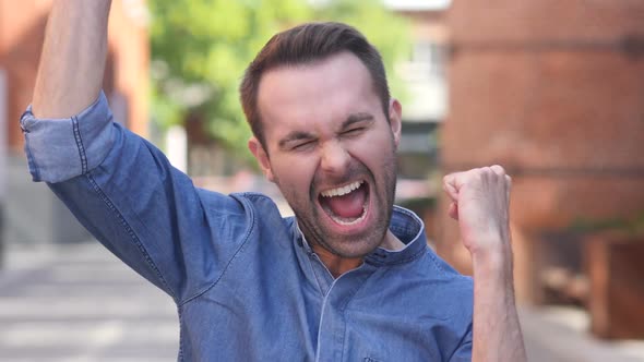 Casual Man Celebrating Success Gesture in Offcie