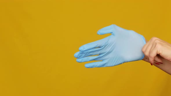 Woman doctor putting on sterile gloves on her hands before surgery close-up.