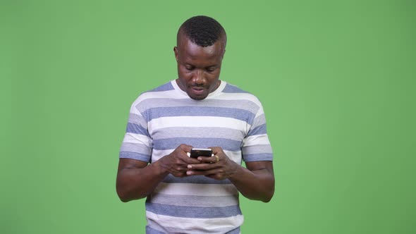 Young Happy African Man Smiling While Using Phone