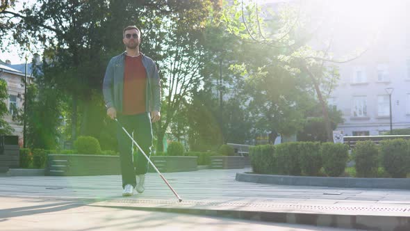 Young Blind Man with Using Safety Stick for Walking Alone Outdoors